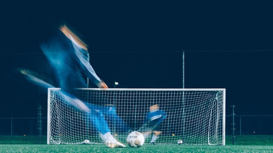 Fußballszene mit Spielern vor dem Tor und einem Ball im Netzbereich